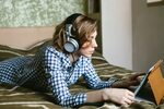 young woman watching video on a tablet at home with headphon